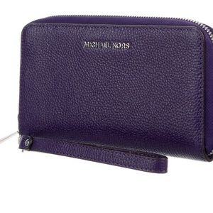 Muchael Kors wristlet wallet with a wrist strap.Silver zipper and silver logo.
